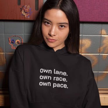 A stylish black women's crop hoodie with the motivational text "Own Lane. Own Race. Own Pace." Perfect for casual wear and athleisure, empowering women to embrace individuality.