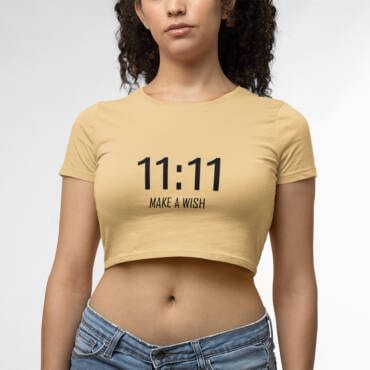 A stylish women's beige crop top with the motivational text "11:11 Make a Wish" printed on it. Perfect for casual and chic outfits, radiating positivity and style.