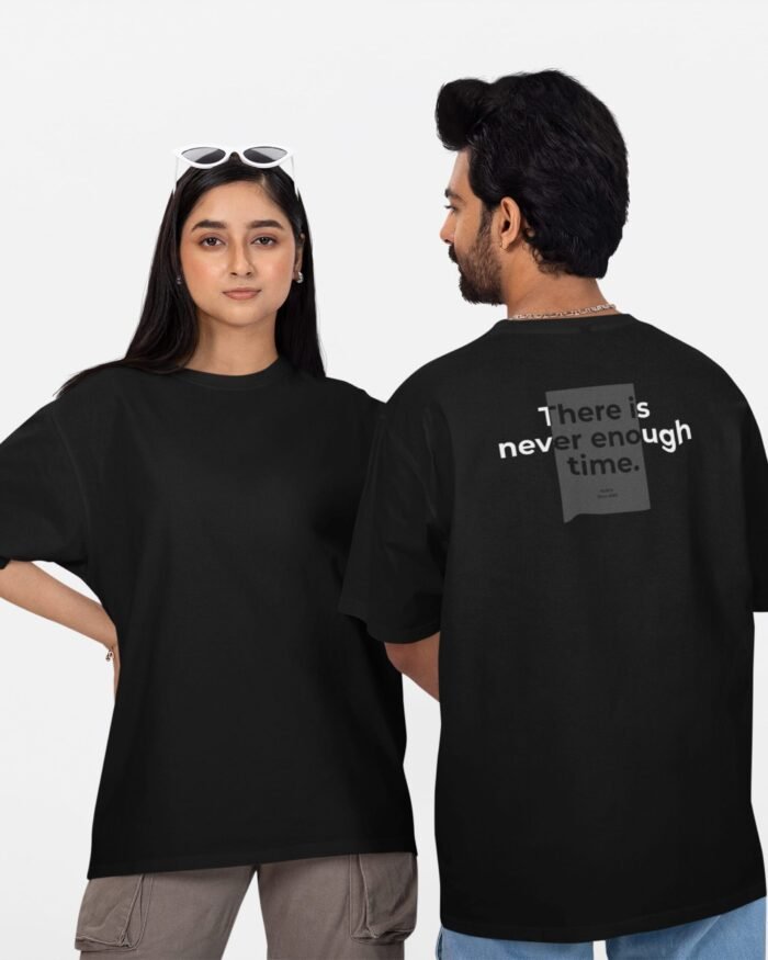 Oversized unisex black t-shirt with a minimalist text print on the back reading "There is never enough time," worn by a male and female model.
