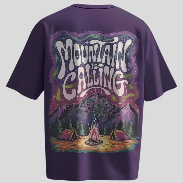 Back view of a purple oversized t-shirt with a colorful camping scene and “Mountain is Calling” typography. Front shows small “Kloch” logo in white.