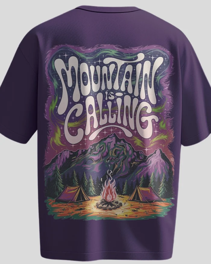 Back view of a purple oversized t-shirt with a colorful camping scene and “Mountain is Calling” typography. Front shows small “Kloch” logo in white.