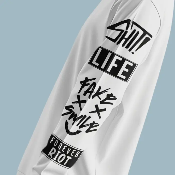 Sleeve Close-Up of Bold Graffiti Text “Shit Life Fake Smile Forever Riot” on White Sweatshirt