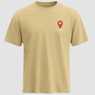 Beige regular fit T-shirt featuring a red location pin graphic with White “I’m Here” text printed in the center.