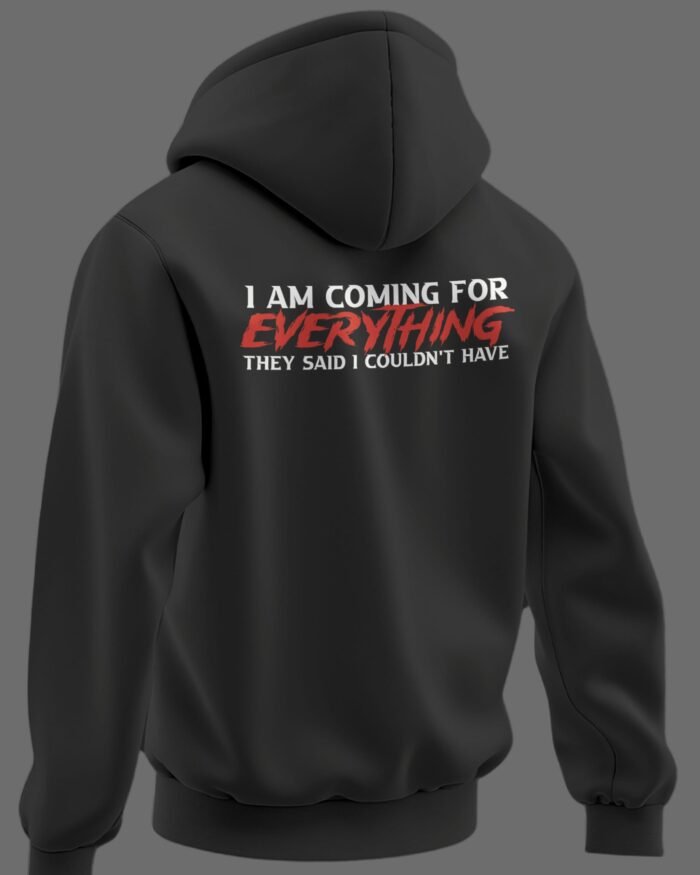 Black oversized hoodie with bold quote on back reading “I AM COMING FOR EVERYTHING THEY SAID I COULDN’T HAVE” in white and red typography.