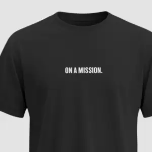 Black t-shirt with bold white uppercase text “ON A MISSION.” printed on the chest